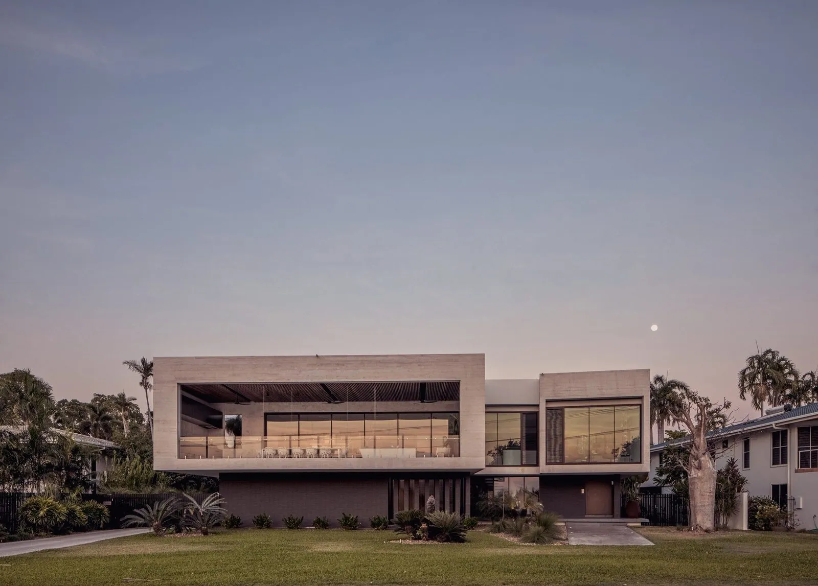 Akşam ışığında iki katlı modern villa cephesi